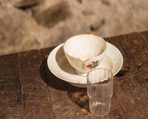 A glass of fresh water and a bowl of traditional quinoa soup on a wooden table